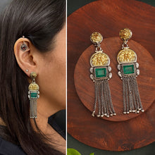 Elevate your style with our Noori Two Tone Silver Earrings. These beautiful long danglers feature a stunning faux emerald in the center, surrounded by gold highlights. Crafted in 92.5 silver, they offer a modern twist on traditional jewelry. Enhance your look with these elegant statement pieces.