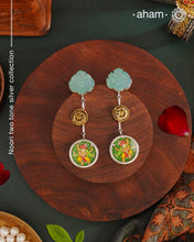 These Noori Two Tone Ganesha Silver Earrings feature a delicate two tone design, adorned with a hand painted miniature ganesha. Made from high quality 92.5 silver, these earrings are both stylish and unique. Elevate your look with the spiritual and cultural significance of these beautifully crafted earrings.