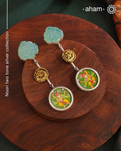 These Noori Two Tone Ganesha Silver Earrings feature a delicate two tone design, adorned with a hand painted miniature ganesha. Made from high quality 92.5 silver, these earrings are both stylish and unique. Elevate your look with the spiritual and cultural significance of these beautifully crafted earrings.