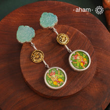 These Noori Two Tone Ganesha Silver Earrings feature a delicate two tone design, adorned with a hand painted miniature ganesha. Made from high quality 92.5 silver, these earrings are both stylish and unique. Elevate your look with the spiritual and cultural significance of these beautifully crafted earrings.