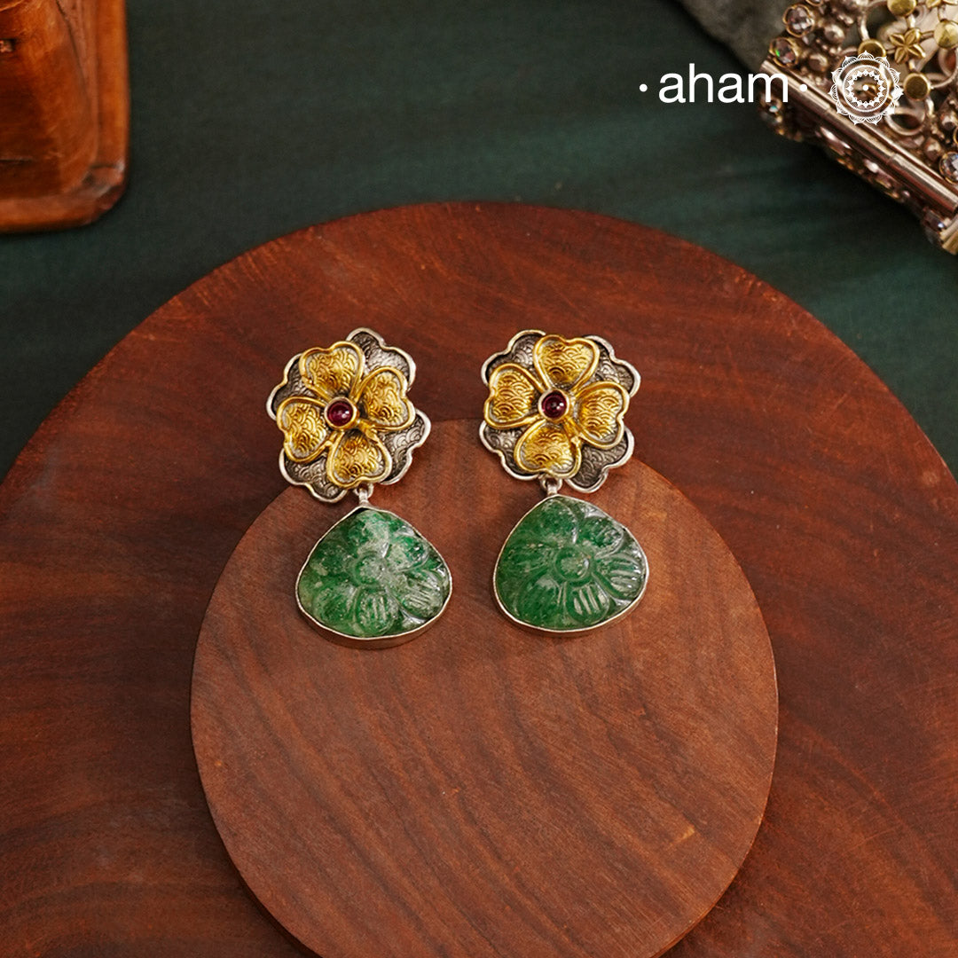 Perfect Two tone flower drop earrings with carved green stone drop. The earrings are handcrafted in 92.5 sterling silver with gold highlights. Style this up with your favourite ethnic or fusion outfits to complete the look.