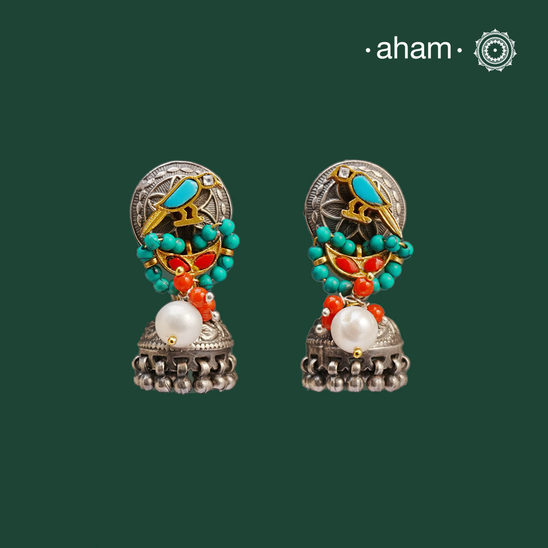 Noori two tone Jhumkie. The earrings are handcrafted in 92.5 sterling silver with gold tone, coral and turquoise highlights. Style this up with your favourite ethnic or fusion outfits to complete the look.