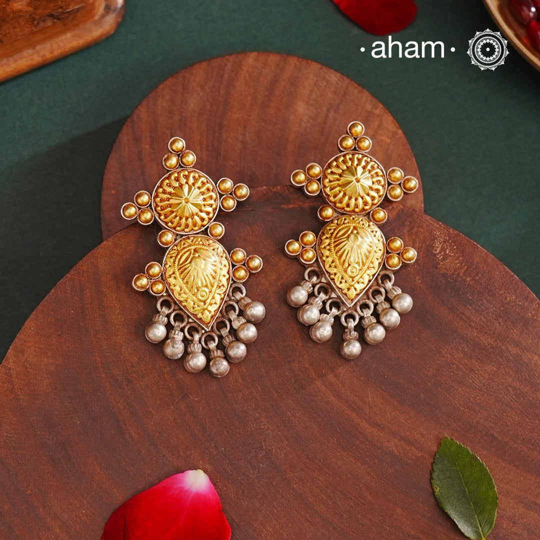 Enhance your style with the timeless elegance of the Dual Tone Silver Earrings. Handcrafted by skilled karigars in Barmer, Rajasthan, this earring features traditional Bandhel work, where a thin sheet of hand beaten 22 carat gold is set on 92.5 silver using a unique wax filling technique. A classic representation of Indian craftsmanship.