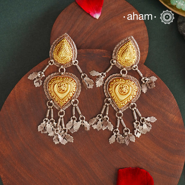 Enhance your style with the timeless elegance of the Dual Tone Silver Earrings. Handcrafted by skilled karigars in Barmer, Rajasthan, this earring features traditional Bandhel work, where a thin sheet of hand beaten 22 carat gold is set on 92.5 silver using a unique wax filling technique. A classic representation of Indian craftsmanship.