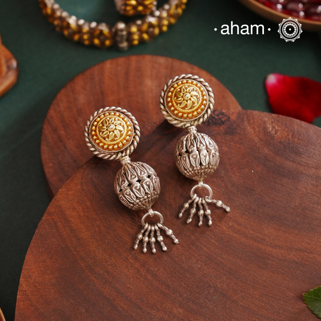 Enhance your style with the timeless elegance of the Dual Tone Silver Earrings. Handcrafted by skilled karigars in Barmer, Rajasthan, this earring features traditional Bandhel work, where a thin sheet of hand beaten 22 carat gold is set on 92.5 silver using a unique wax filling technique. A classic representation of Indian craftsmanship.