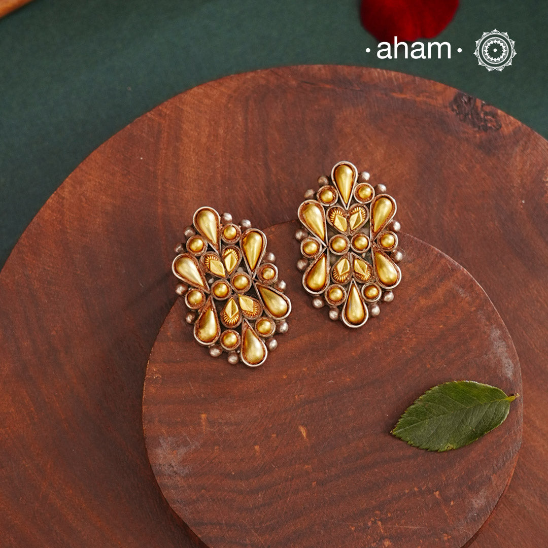 Enhance your style with the timeless elegance of the Dual Tone Silver Earrings. Handcrafted by skilled karigars in Barmer, Rajasthan, this earring features traditional Bandhel work, where a thin sheet of hand beaten 22 carat gold is set on 92.5 silver using a unique wax filling technique. A classic representation of Indian craftsmanship.