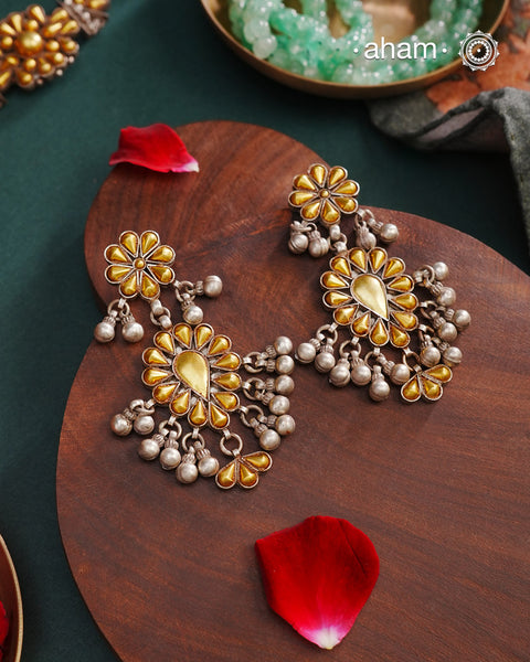 Enhance your style with the timeless elegance of the Dual Tone Silver Earrings. Handcrafted by skilled karigars in Barmer, Rajasthan, this earring features traditional Bandhel work, where a thin sheet of hand beaten 22 carat gold is set on 92.5 silver using a unique wax filling technique. A classic representation of Indian craftsmanship.