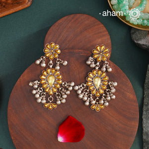 Enhance your style with the timeless elegance of the Dual Tone Silver Earrings. Handcrafted by skilled karigars in Barmer, Rajasthan, this earring features traditional Bandhel work, where a thin sheet of hand beaten 22 carat gold is set on 92.5 silver using a unique wax filling technique. A classic representation of Indian craftsmanship.