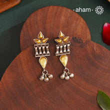 Enhance your style with the timeless elegance of the Dual Tone Silver Earrings. Handcrafted by skilled karigars in Barmer, Rajasthan, this earring features traditional Bandhel work, where a thin sheet of hand beaten 22 carat gold is set on 92.5 silver using a unique wax filling technique. A classic representation of Indian craftsmanship.