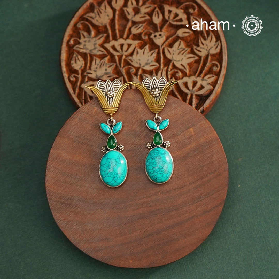 Noori two tone Earrings. The earrings are handcrafted in 92.5 sterling silver with turquoise stone and gold highlights. Style this up with your favourite ethnic or indo western outfits to complete the look.
