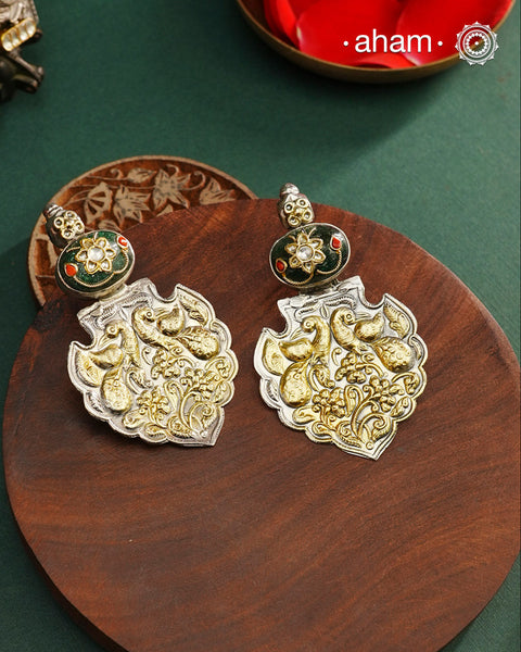 Enhance your look with our Noori Two Tone Silver Earrings! These elegant earrings feature a beautiful inlay work stone highlight with elegant peacock motifs. Crafted in 92.5 silver.&nbsp;