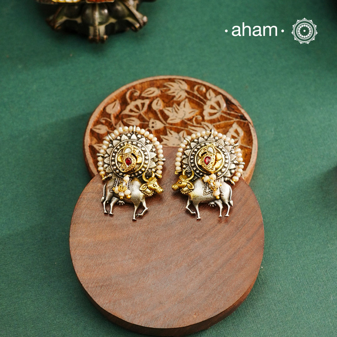 Noori dual tone cow Earrings. The earrings are handcrafted in 92.5 sterling silver with kuand, pearl and gold highlights. Style this up with your favourite ethnic or fusion outfits to complete the look.