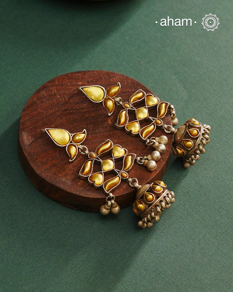 Enhance your style with the timeless elegance of the Dual Tone Silver Earrings. Handcrafted by skilled karigars in Barmer, Rajasthan, this earring features traditional Bandhel work, where a thin sheet of hand beaten 22 carat gold is fused with 92.5 silver and then set on 92.5 silver using a unique wax filling technique. A classic representation of Indian craftsmanship.