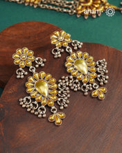 Enhance your style with the timeless elegance of the Dual Tone Silver Earrings. Handcrafted by skilled karigars in Barmer, Rajasthan, this earring features traditional Bandhel work, where a thin sheet of hand beaten 22 carat gold is fused with 92.5 silver and then set on 92.5 silver using a unique wax filling technique. A classic representation of Indian craftsmanship.&nbsp;