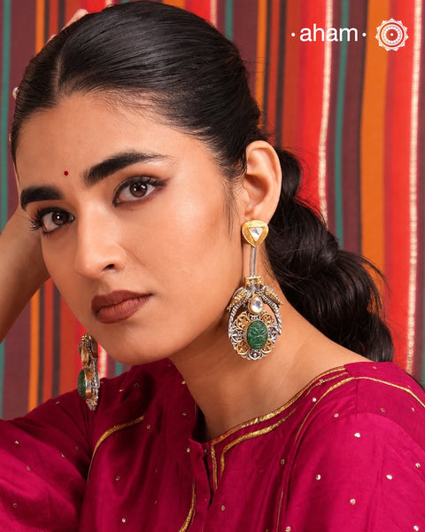 Noori two tone earrings are handcrafted in 92.5 sterling silver with kundan and gold highlights and carved green stone in the center. Style this one of a kind earring with your favourite ethnic or fusion outfits to complete the look.
