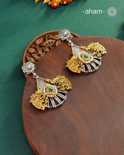 Noori two tone Peacock Earrings handcrafted in 92.5 sterling silver with kundan and gold highlights.tyle this up with your favourite ethnic or fusion outfits to complete the look.