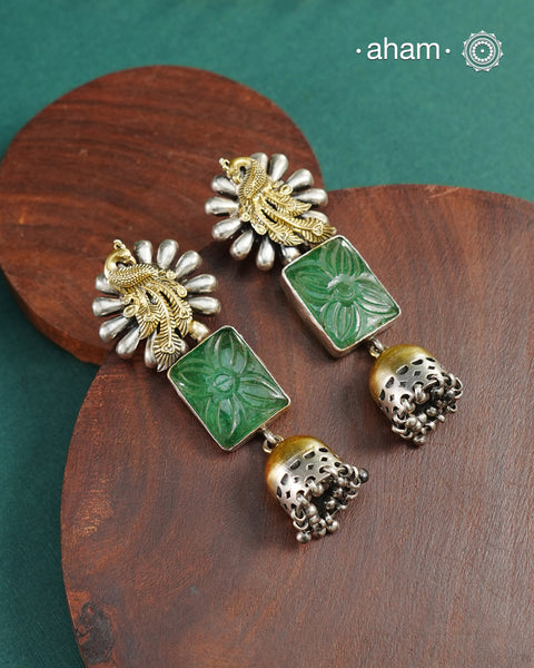 Noori two tone jhumkies handcrafted in 92.5 sterling silver with cut stone and gold highlights. Style this up with your favourite ethnic or fusion outfits to complete the look.