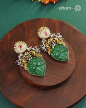 Noori two tone earrings are handcrafted in 92.5 sterling silver with kundan and gold highlights and carved green stone in the center.Style this one of a kind earring with your favourite ethnic or fusion outfits to complete the look.
