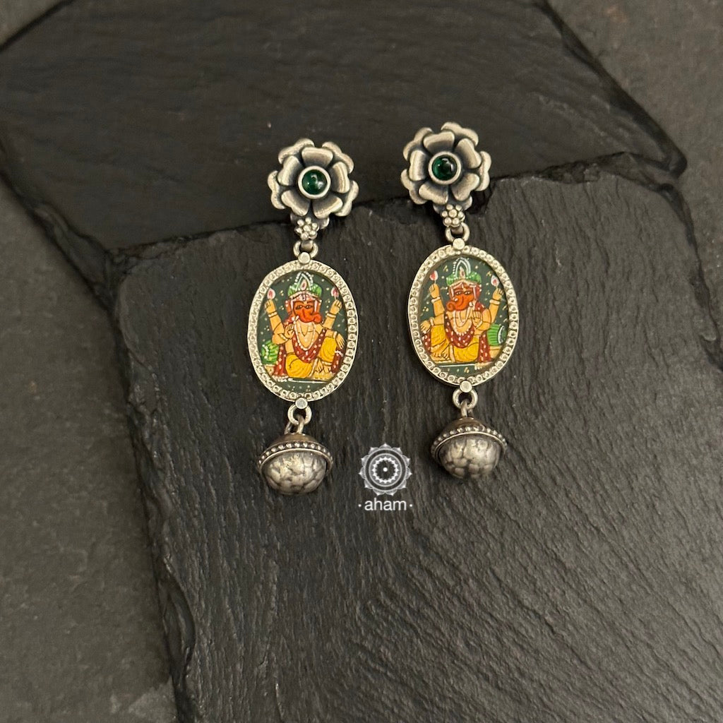 Light weight silver earrings with intricate miniature hand painted Ganesha motif in vibrant colours, enclosed with a glass top.