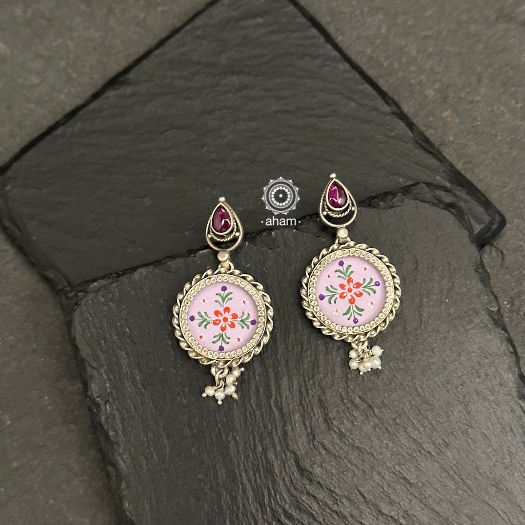 Delicate silver drop earrings featuring a flower stud and cultured pearls. Masterfully hand-painted with a detailed miniature floral design, enclosed in a glass top. Ideal for everyday wear.