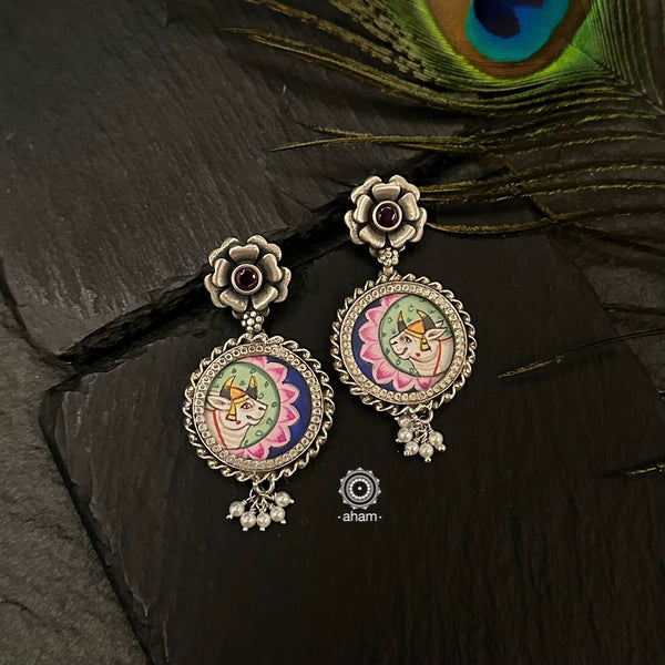 Hand painted silver drop earrings with intricate Pichwai miniature painting done by skilful artisans enclosed with a glass top. Perfect everyday wear earrings. 