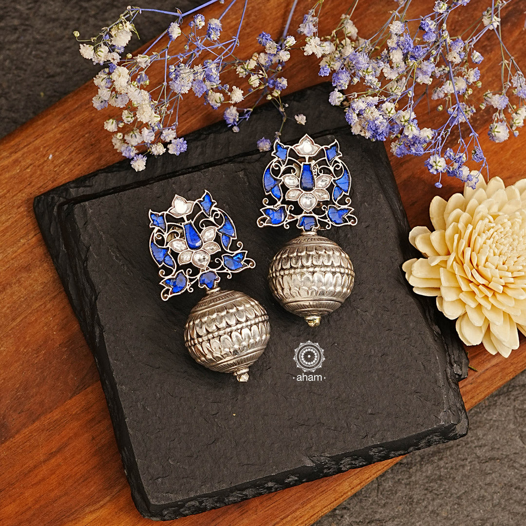 Make a statement with these stunning Ira Drop Silver Earrings. Handcrafted in 92.5 sterling silver, the earring is adorned with an elegant blue kundan setting for a sophisticated look. Pairs beautifully with an evening gown. 
