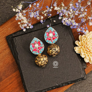 The Ira Drop Silver Earrings feature dual tones of silver and gold polish for a stunning look. The earrings are embellished with turquoise and rani pink kundan and highlighted with chitai work drop ball. A luxurious and elegant accessory perfect for any occasion.