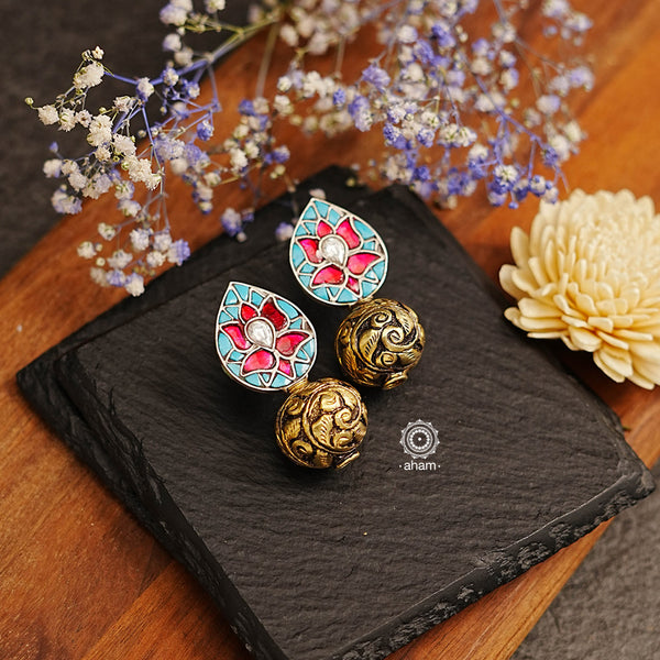 The Ira Drop Silver Earrings feature dual tones of silver and gold polish for a stunning look. The earrings are embellished with turquoise and rani pink kundan and highlighted with chitai work drop ball. A luxurious and elegant accessory perfect for any occasion.