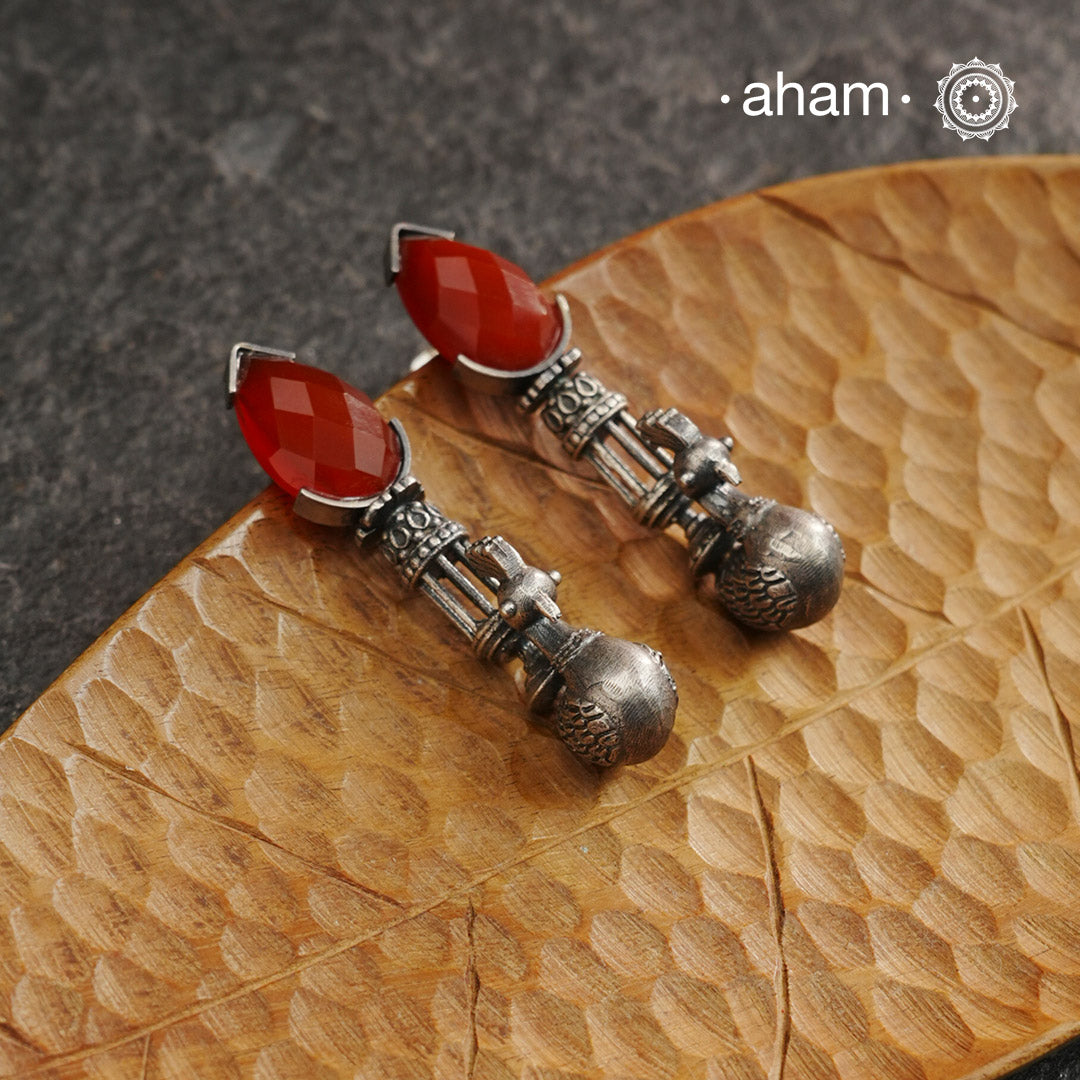 Enhance your style with these Ira Carnelian Peacock Silver Earrings. The stunning peacock design and vibrant carnelian stone create a unique and understated look. Handcrafted in 92.5 silver, these earrings are a perfect addition to any jewellery collection.