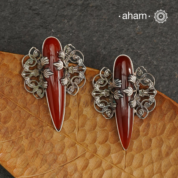 Elevate any look with our Ira Carnelian Stone Silver Earrings. These stunning statement earrings feature a carnelian drop with intricate silver filigree patterns, crafted in 92.5 silver. Perfect for formal events, these earrings add a touch of elegance and sophistication.