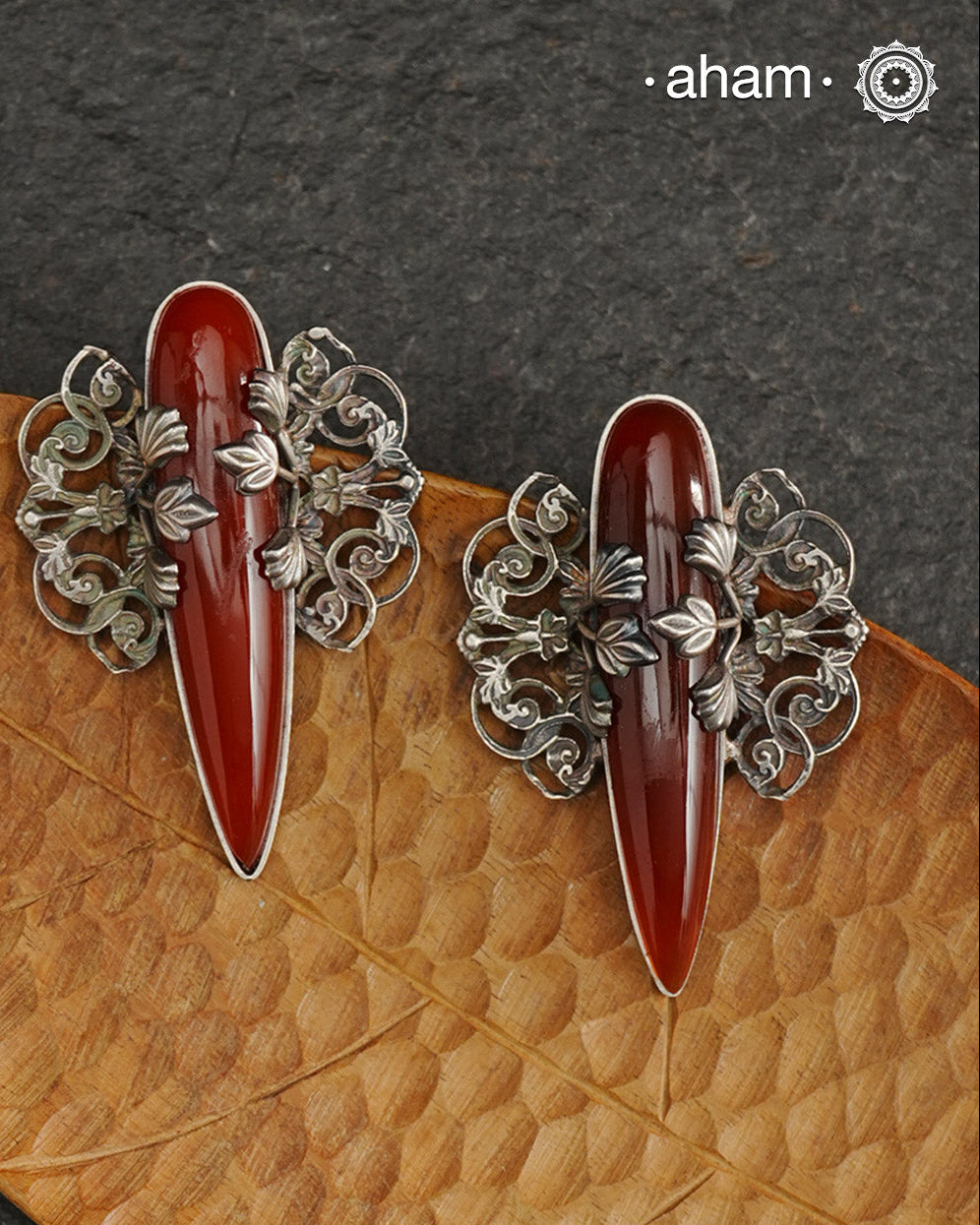Elevate any look with our Ira Carnelian Stone Silver Earrings. These stunning statement earrings feature a carnelian drop with intricate silver filigree patterns, crafted in 92.5 silver. Perfect for formal events, these earrings add a touch of elegance and sophistication.