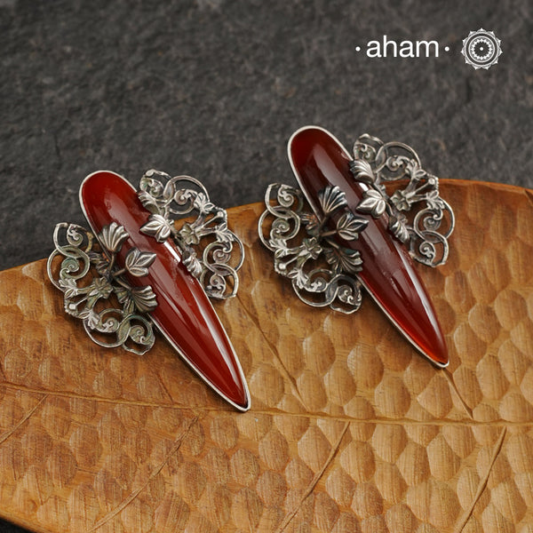 Elevate any look with our Ira Carnelian Stone Silver Earrings. These stunning statement earrings feature a carnelian drop with intricate silver filigree patterns, crafted in 92.5 silver. Perfect for formal events, these earrings add a touch of elegance and sophistication.