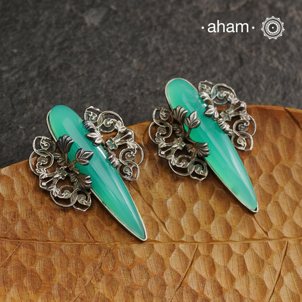 Elevate any look with our Ira Sea Green Stone Silver Earrings. These stunning statement earrings feature a sea green stone drop with intricate silver filigree patterns, crafted in 92.5 silver. Perfect for formal events, these earrings add a touch of elegance and sophistication.
