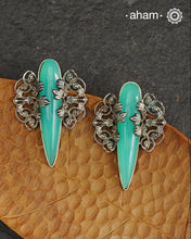 Elevate any look with our Ira Sea Green Stone Silver Earrings. These stunning statement earrings feature a sea green stone drop with intricate silver filigree patterns, crafted in 92.5 silver. Perfect for formal events, these earrings add a touch of elegance and sophistication.