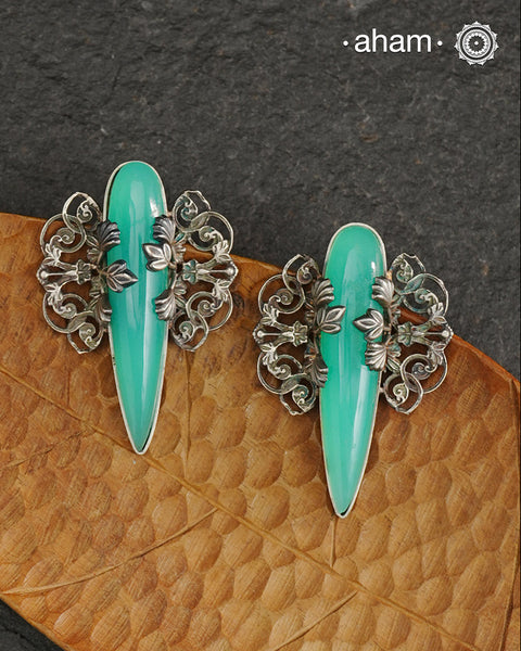 Elevate any look with our Ira Sea Green Stone Silver Earrings. These stunning statement earrings feature a sea green stone drop with intricate silver filigree patterns, crafted in 92.5 silver. Perfect for formal events, these earrings add a touch of elegance and sophistication.