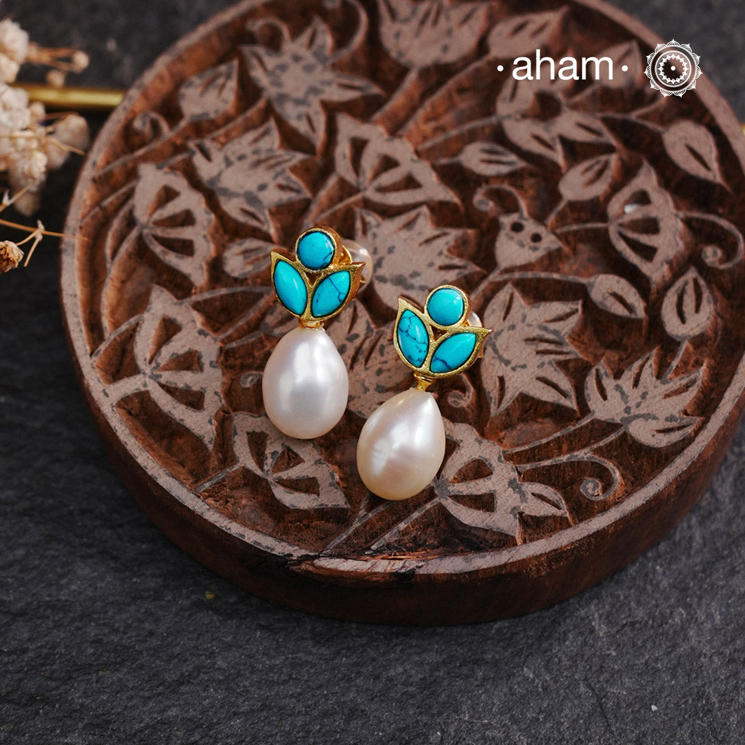 Add a touch of elegance to your outfit with our Turquoise Pearl Drop Gold Polish Silver Earrings. These earrings feature a beautiful turquoise pearl drop, complimented by a gold polish and silver base. Perfect for both formal and casual occasions, they are sure to elevate your style.