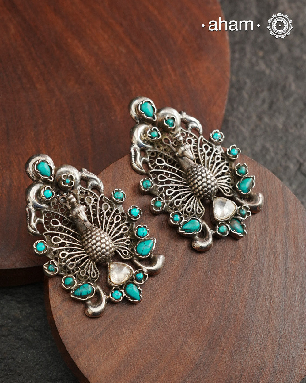 Experience the majestic beauty of the peacock with our Ira Peacock Silver Earrings. Crafted in 92.5 silver and highlighted with turquoise stones, these earrings showcase the intricate details of this magnificent bird. Elevate your style and add a touch of nature-inspired elegance to your wardrobe.