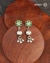 The Ira Silver Earrings are the perfect accent for your wardrobe. Crafted in silver with green kundan highlight on the top.