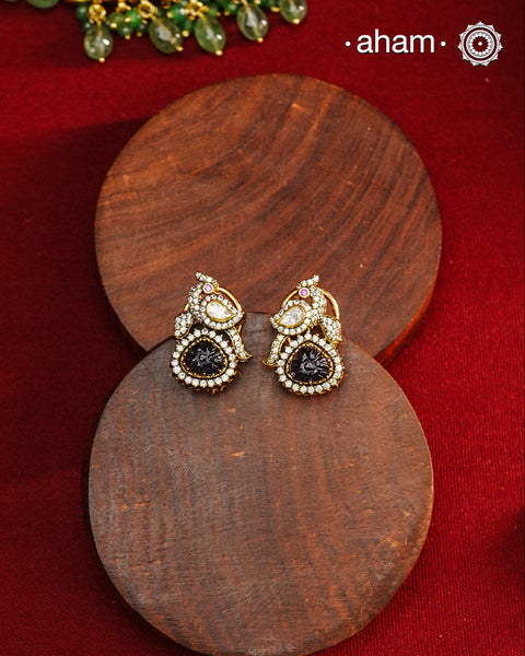 These expertly crafted studs feature 92.5% sterling silver with a fine gold polish finish, elegantly set with brilliant moissanite stones and a lustrous deep purple stone drop. Designed to offer lasting shine and sophistication making them a perfect choice for both everyday wear and special occasions. 