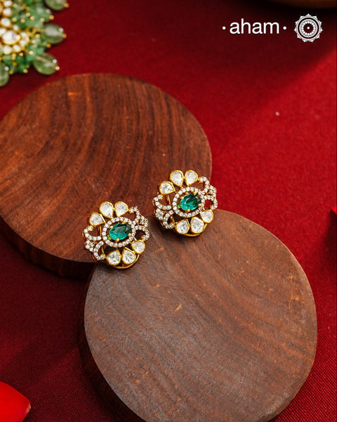 These expertly crafted studs feature 92.5% sterling silver with a fine gold polish finish, elegantly set with brilliant moissanite stones and a lustrous green stone in the center. Designed to offer lasting shine and sophistication making them a perfect choice for both everyday wear and special occasions.