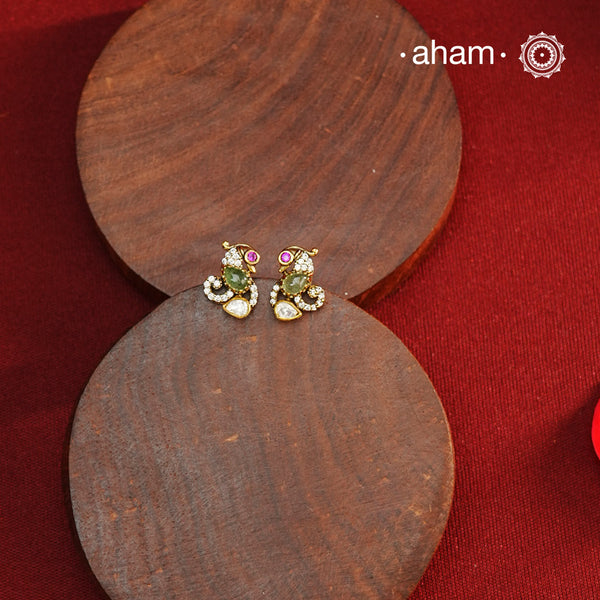 These expertly crafted studs feature 92.5% sterling silver with a fine gold polish finish, elegantly set with brilliant moissanite stones and a lustrous green stone in the center. Designed to offer lasting shine and sophistication making them a perfect choice for both everyday wear and special occasions.  