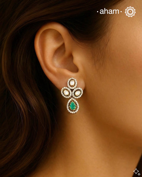 Expertly crafted earrings in 92.5% sterling silver with a fine gold polish finish, elegantly set with brilliant moissanite stones and a lustrous green stone in the center. Designed to offer lasting shine and sophistication making them a perfect choice for special occasions. &nbsp;