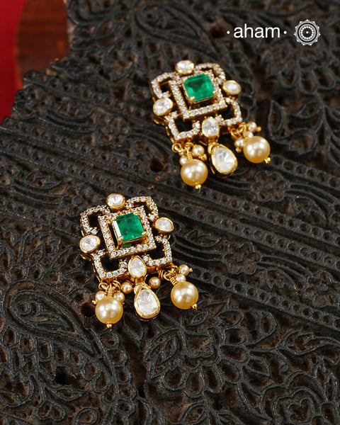Thoughtfully crafted in 92.5 sterling silver with a fine gold polish, these studs celebrate timeless design and fine craftsmanship. A luminous green stone takes center stage, framed by shimmering moissanites that catch the light beautifully. Refined, versatile, and easy to wear, they are designed to become a favourite for years to come.
