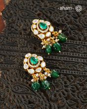 Thoughtfully crafted in 92.5 sterling silver with a fine gold polish, these studs celebrate timeless design and fine craftsmanship. A luminous green stone takes center stage, framed by shimmering moissanites that catch the light beautifully. Refined, versatile, and easy to wear, they are designed to become a favourite for years to come.