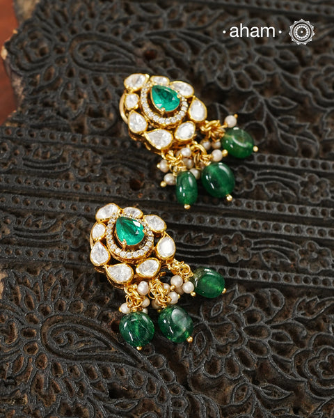 Thoughtfully crafted in 92.5 sterling silver with a fine gold polish, these studs celebrate timeless design and fine craftsmanship. A luminous green stone takes center stage, framed by shimmering moissanites that catch the light beautifully. Refined, versatile, and easy to wear, they are designed to become a favourite for years to come.