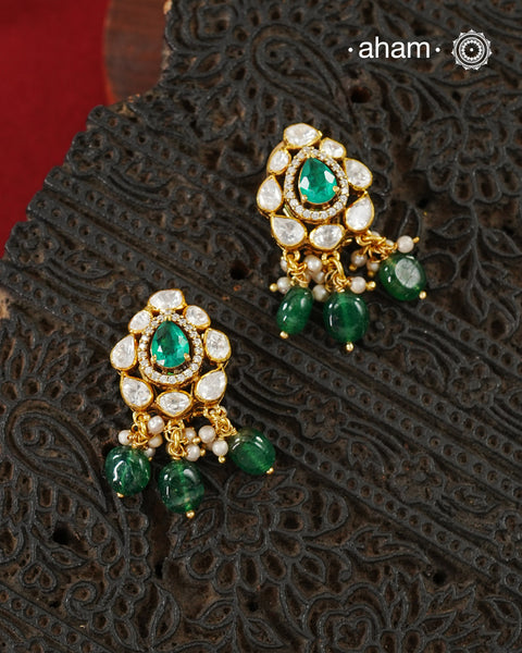 Thoughtfully crafted in 92.5 sterling silver with a fine gold polish, these studs celebrate timeless design and fine craftsmanship. A luminous green stone takes center stage, framed by shimmering moissanites that catch the light beautifully. Refined, versatile, and easy to wear, they are designed to become a favourite for years to come.