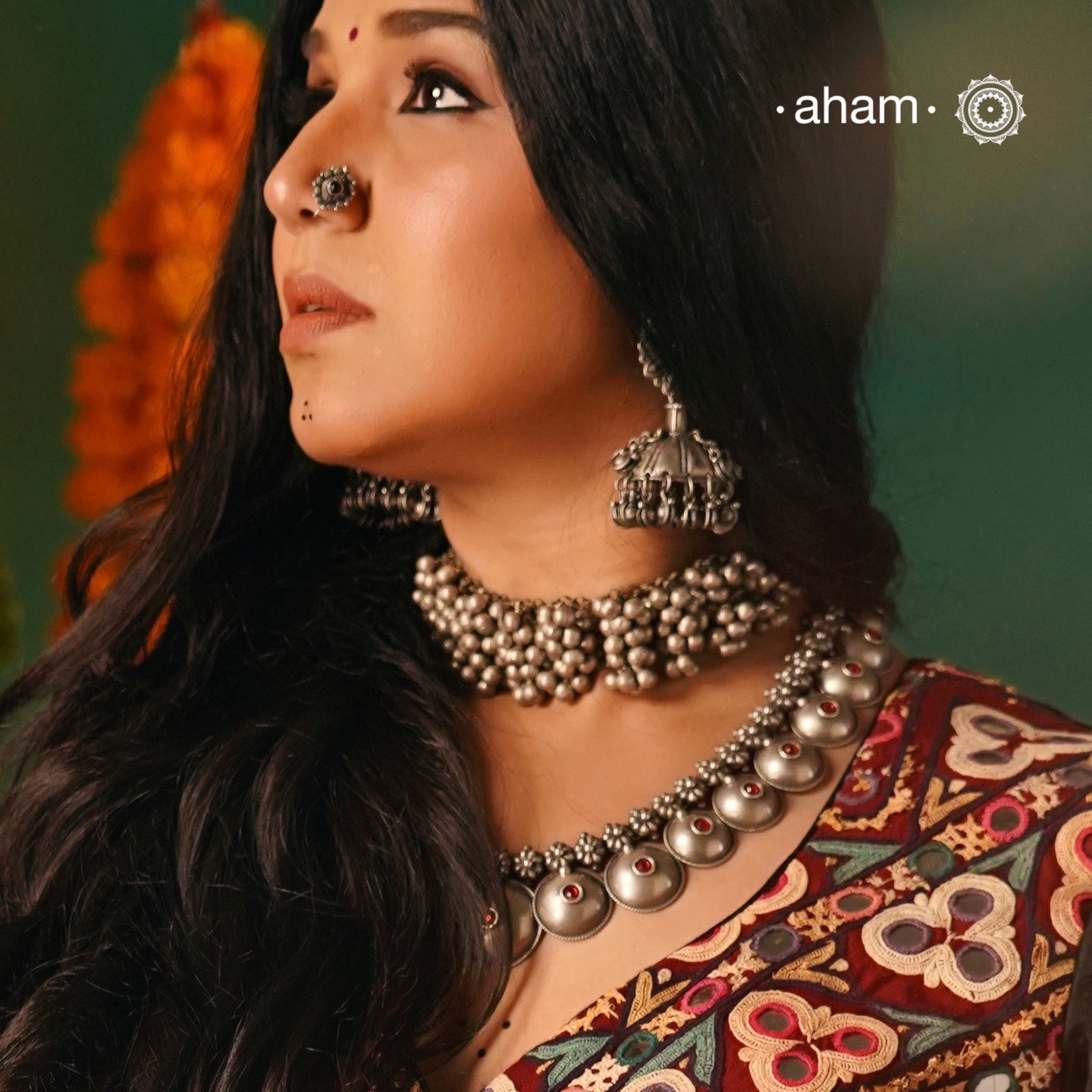 Experience the versatility and cultural charm with our Tribal Ghungroo Silver Choker. Adorned with multiple ghungroos, it can be styled as a choker, arm band, as gajra in your hair or as a bracelet, allowing you to get creative with your look this Navratri. Made of silver, this piece will add an elegant touch to any outfit.