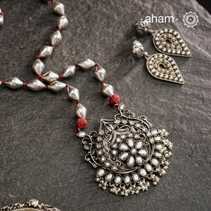 The Mewad Silver Neckpiece exemplifies superior craftsmanship with its intricate pendant design featuring a refined pearl setting. Meticulously crafted from 92.5 sterling silver, this piece combines traditional artistry with the distinctive texture of a dholki bead chain. The pendant's detailed silverwork demonstrates exceptional technical precision, creating a sophisticated adornment that honours traditional metalsmithing techniques while offering contemporary elegance.