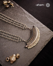 The Mewad Silver Neckpiece is a captivating accessory featuring a boat-shaped amulet delicately adorned with tiny pearls. Crafted from 92.5% pure silver, its side chains are embellished with elegant vintage-style flowers. This statement piece blends classic charm with subtle sophistication, making it the perfect addition to elevate your style effortlessly.