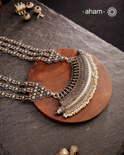 The Mewad Silver Neckpiece is a captivating accessory featuring a boat-shaped amulet delicately adorned with tiny pearls. Crafted from 92.5% pure silver, its side chains are embellished with elegant vintage-style flowers. This statement piece blends classic charm with subtle sophistication, making it the perfect addition to elevate your style effortlessly.
